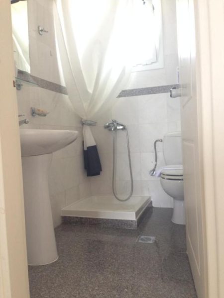 Baño completo con ducha, lavabo y aseo en Kanakis Blue Beach Apartments