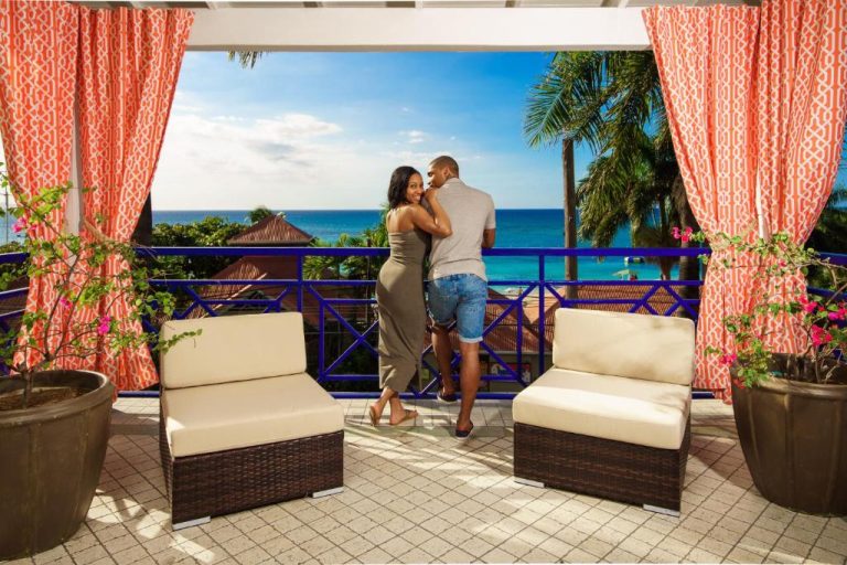 Pareja romántica en terraza con vista al mar del Deja Resort All Inclusive Jamaica