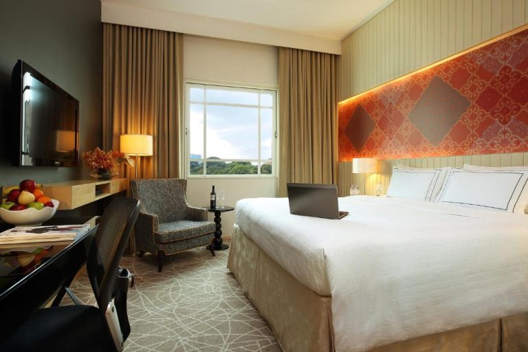 Habitación deluxe con cama king size y laptop en Rendezvous Hotel Singapore by Far East Hospitality