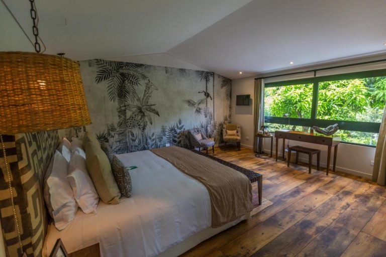 Habitación doble con mural de selva, suelo de madera y vistas al jardín en Patio del Mundo