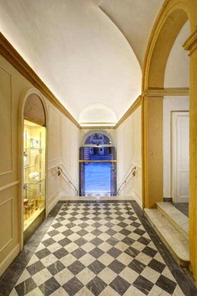 Elegante hall de entrada con suelo de mármol a cuadros y bóvedas en Locanda della Posta Etruria Collection