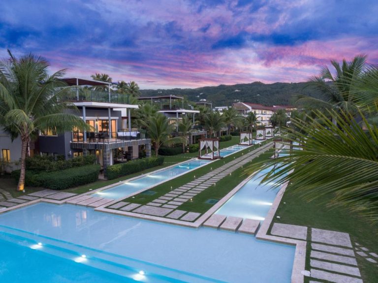 Piscinas exteriores con jardines tropicales y cabañas del Sublime Samaná Hotel al atardecer