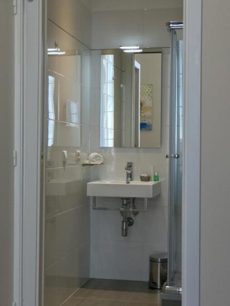 Baño moderno con ducha de cristal y lavabo en Boutique Hôtel Neptune Nice