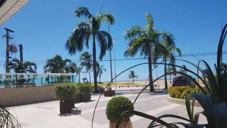Terraza exterior con palmeras y vistas al mar del Apart Terraços do Atlântico en Brasil
