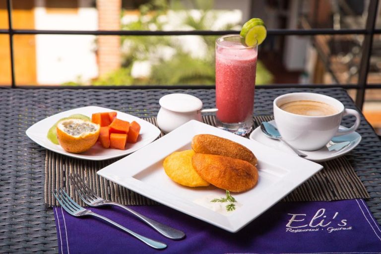 Desayuno típico colombiano con arepas, frutas tropicales y jugo en Hotel Boutique Casa Carolina Santa Marta