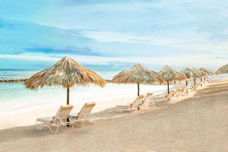 Playa privada del Hyatt Ziva Rose Hall con tumbonas y sombrillas de palma frente al mar turquesa