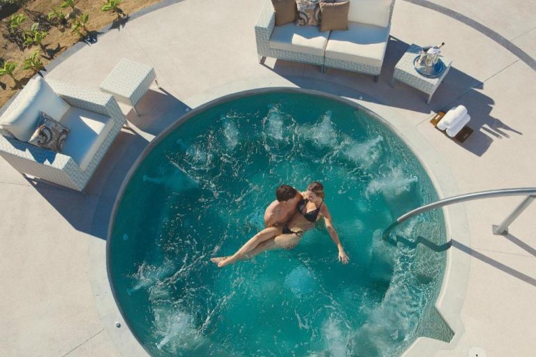 Pareja disfrutando del jacuzzi privado circular en Secrets Puerto Los Cabos Golf & Spa adults only