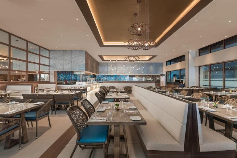Elegante restaurante interior del Henann Crystal Sands Resort con mesas preparadas y decoración moderna