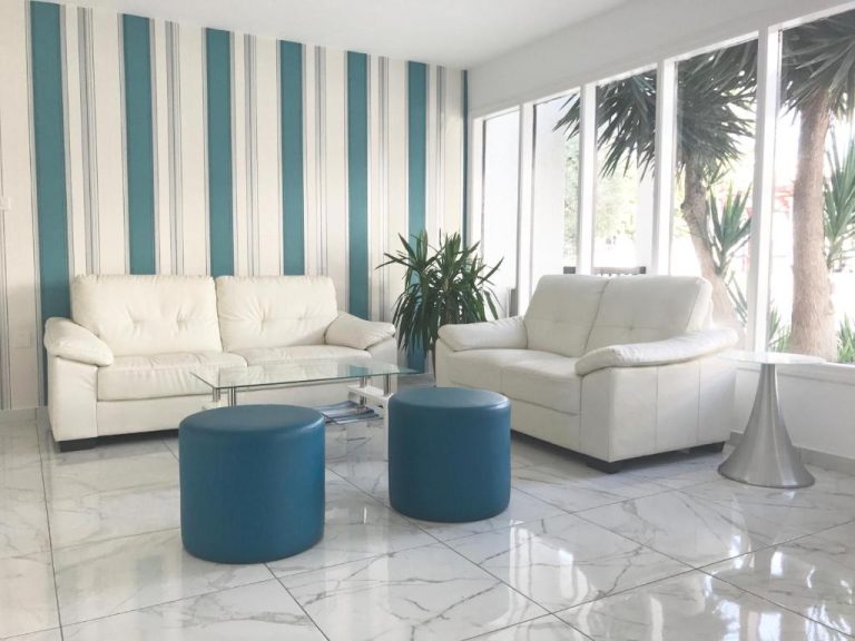 Sala de estar moderna con sofás blancos y otomanas azules en Margarita Napa Apartments