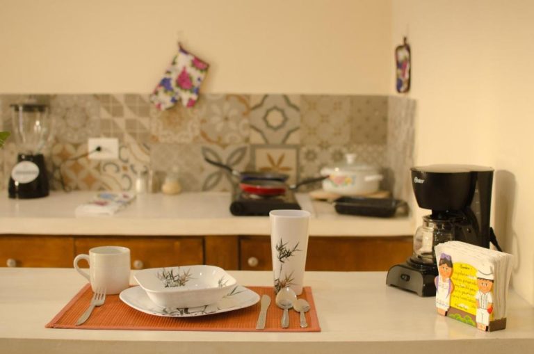Cocina equipada con cafetera, utensilios y mesa de desayuno lista para usar en Casa Xanath