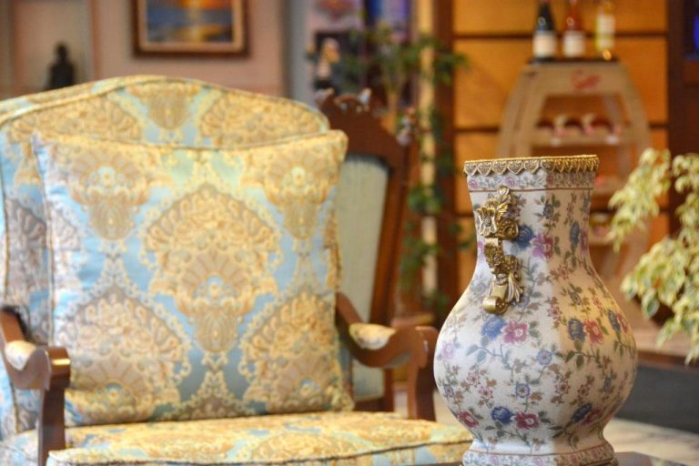 Sillón clásico tapizado y jarrón de porcelana floral en el salón del Istankoy Hotel