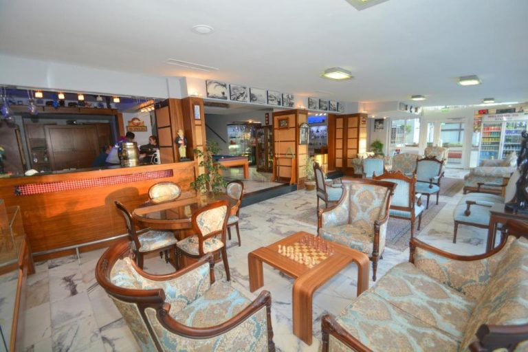 Elegante lobby del Istankoy Hotel con sillones clásicos, tablero de ajedrez y zona de bar