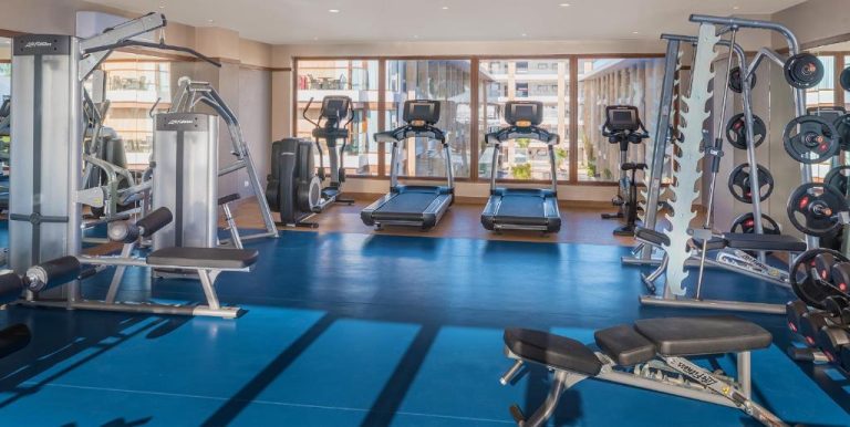 Gimnasio completamente equipado con cintas de correr y máquinas de musculación en Henann Crystal Sands Resort