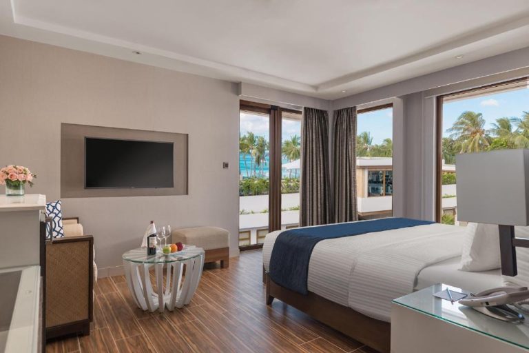 Habitación deluxe con cama doble y vistas al mar turquesa en Henann Crystal Sands Resort Boracay