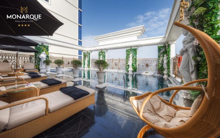 Piscina en terraza exterior con tumbonas y estatuas clásicas del Monarque Hotel Danang
