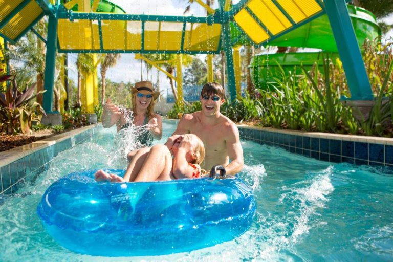 Familia disfrutando del río lento con flotador azul en The Grove Resort & Water Park Orlando