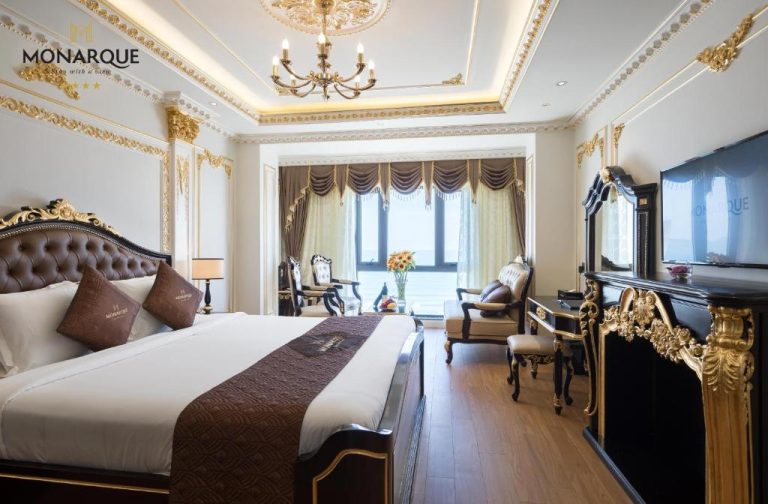 Suite de lujo con decoración barroca dorada y cama king size en Monarque Hotel Danang