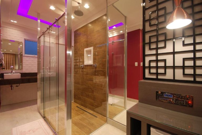 Baño de lujo con ducha de cristal e iluminación LED morada en Glória Plaza Hotel Adults Only