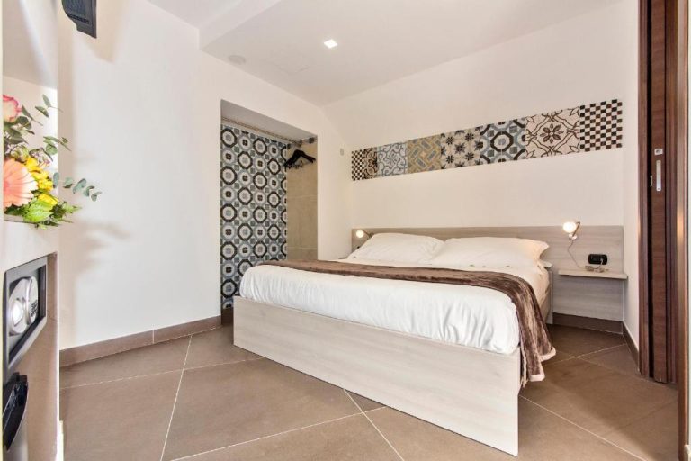 Habitación doble con cama matrimonial y decoración de azulejos en San Giorgio Palace Hotel Ragusa Ibla