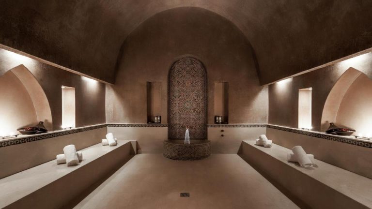 Sala de hammam tradicional marroquí con mesas de masaje y decoración árabe en Tikida Golf Palace