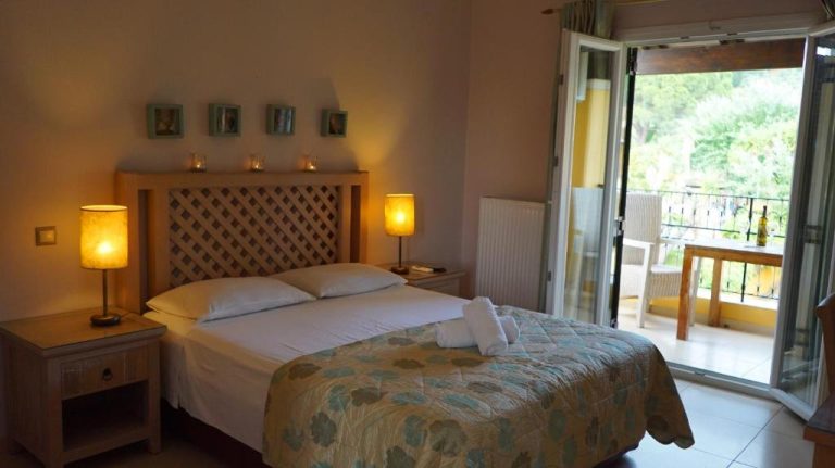 Habitación doble con cama matrimonial y terraza con vistas al jardín en Spiti Nikos
