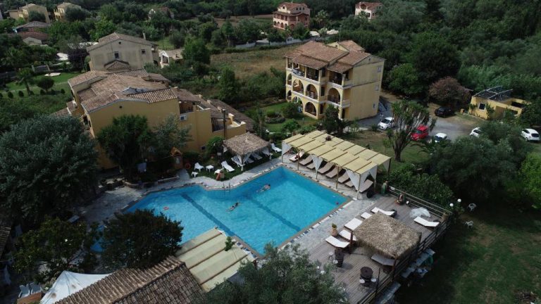 Vista aérea de la piscina exterior con tumbonas y jardines del hotel Spiti Nikos en Grecia
