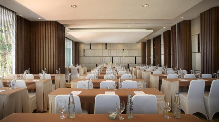 Amplio salón de reuniones y conferencias del Hotel Santika Siligita Nusa Dua con mesas y sillas blancas