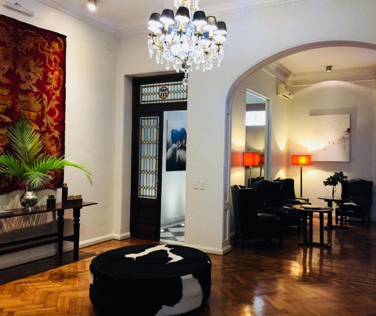 Elegante lobby del Magnolia Hotel Boutique con lámpara de araña, suelo de parqué y decoración clásica contemporánea