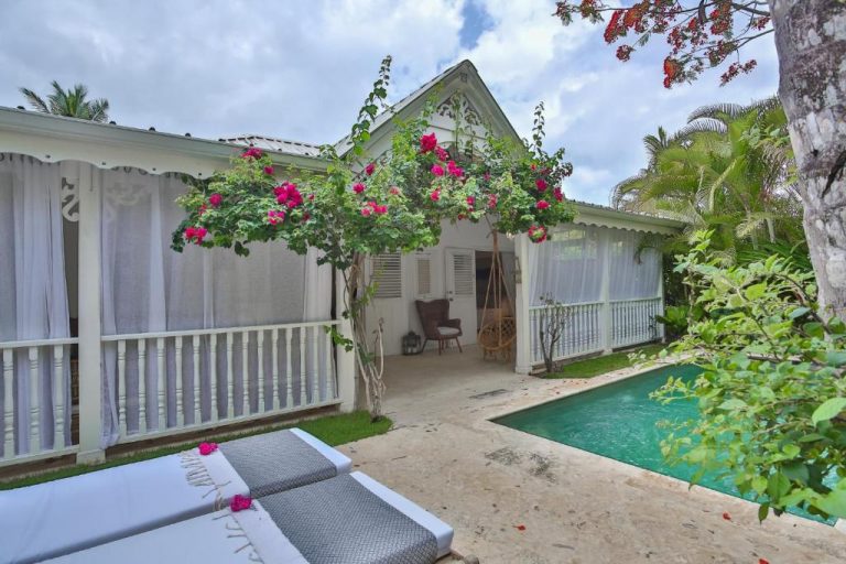 Villa con piscina privada y terraza con tumbonas en Mahona Boutique Hotel rodeada de vegetación tropical