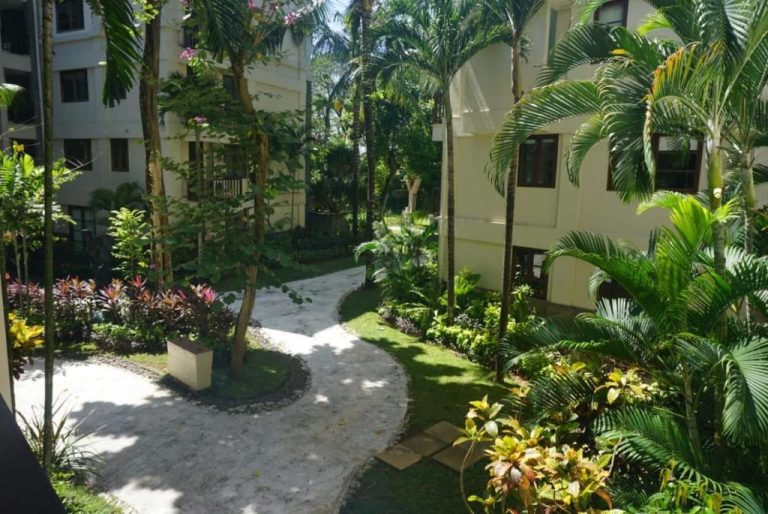Jardines tropicales con sendero peatonal y palmeras en el Hotel Ruby Nusa Dua Bali