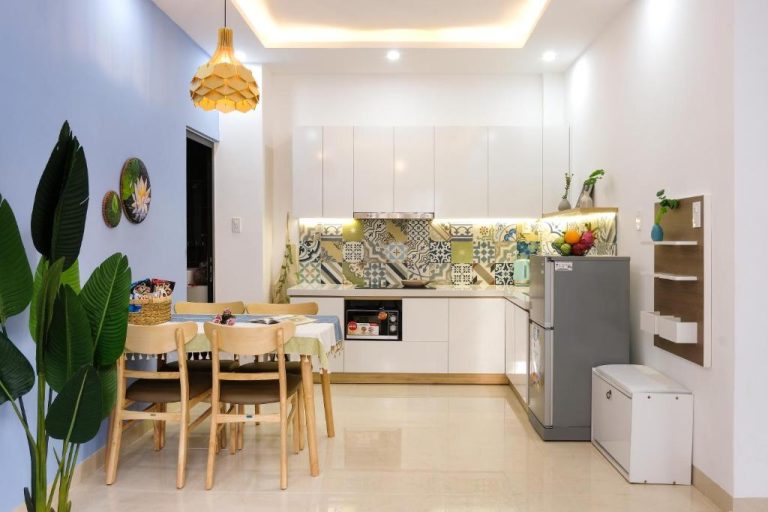 Cocina y comedor modernos con azulejos decorativos y mesa de madera en Phuong Tran Apartment and Hotel
