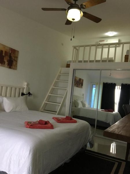 Habitación doble con cama king, litera en altillo y espejo de cuerpo entero en The Beachhouse Cebu
