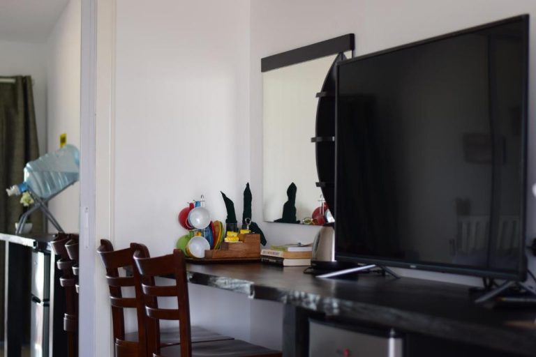 Habitación con televisor de pantalla plana y escritorio en The Beachhouse Cebu