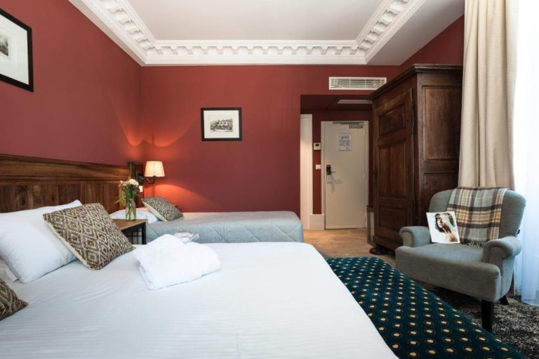 Habitación doble clásica con paredes rojas y molduras blancas en el Château de Saulon