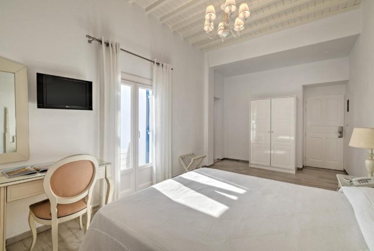 Habitación doble con decoración blanca y vistas al mar en el Hotel Alkyon