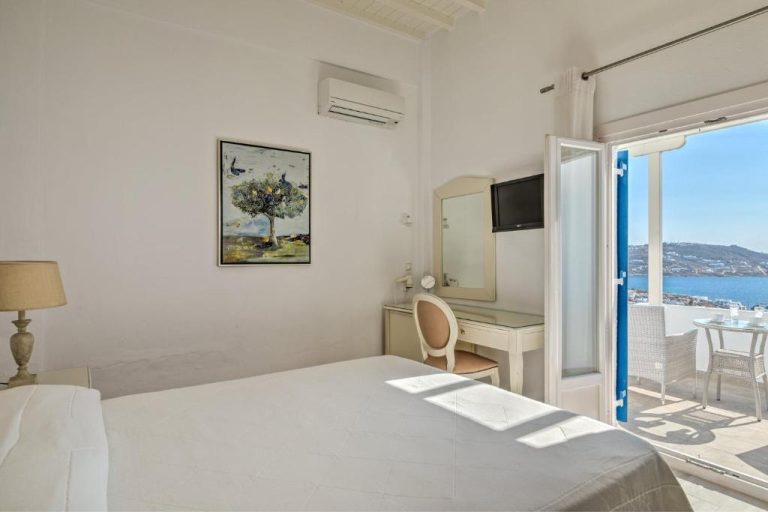 Habitación doble con cama blanca y terraza con vistas al mar en Hotel Alkyon Mykonos
