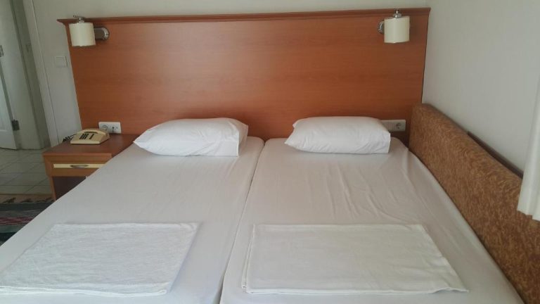 Habitación doble con dos camas individuales y cabecero de madera en Cicek Hotel & Apartments