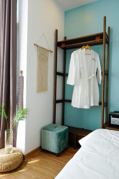 Habitación con armario de madera y albornoz blanco en Phuong Tran Apartment and Hotel
