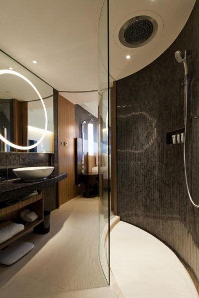 Baño de lujo con ducha de lluvia empotrada y paredes de mosaico oscuro en Hotel ICON