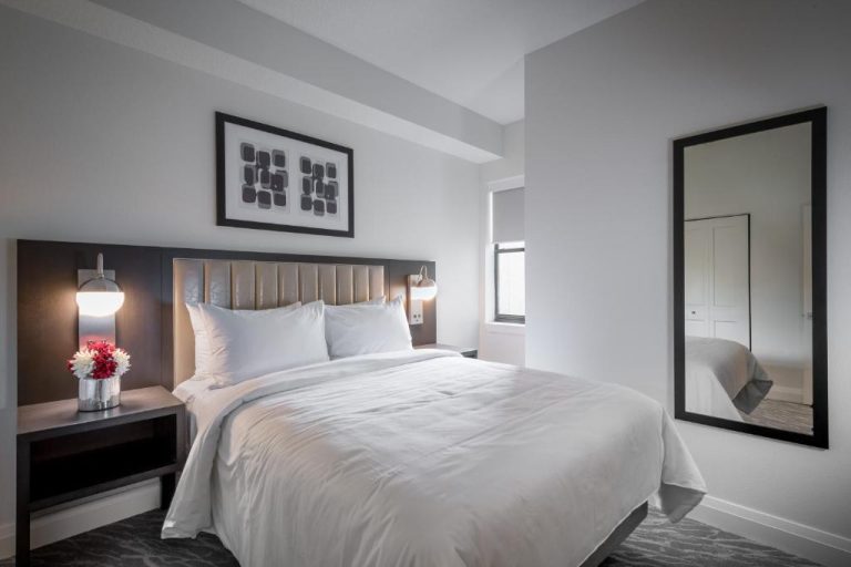 Habitación elegante con cama doble y espejo de cuerpo entero en The Grove Resort Orlando