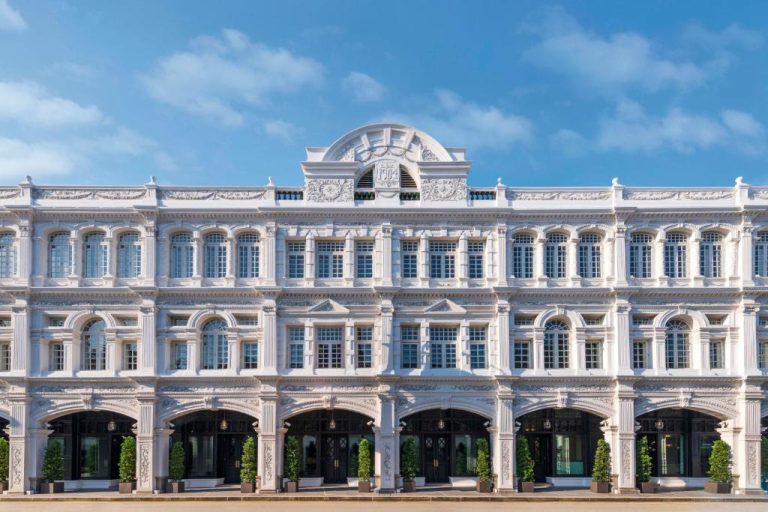 Majestuosa fachada colonial blanca del Capitol Kempinski Hotel Singapore con arcos y ornamentos clásicos