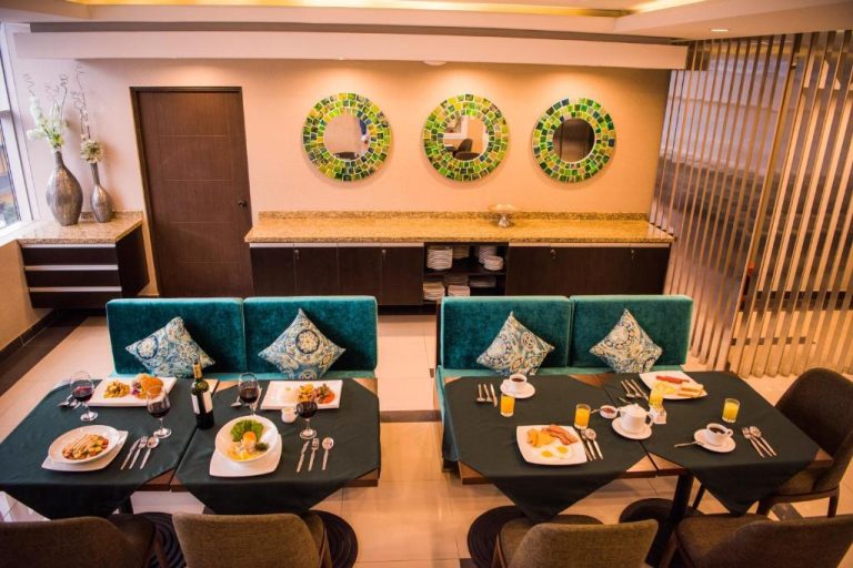 Restaurante del Hotel Diamond Lima con mesas servidas para desayuno y decoración de espejos mosaico verdes