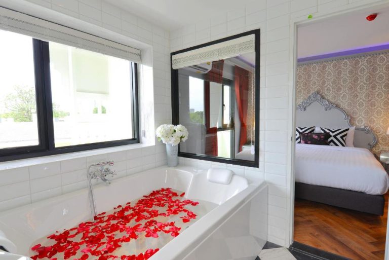 Bañera romántica con pétalos de rosa en suite del Villa De Khaosan by Chillax con dormitorio de lujo