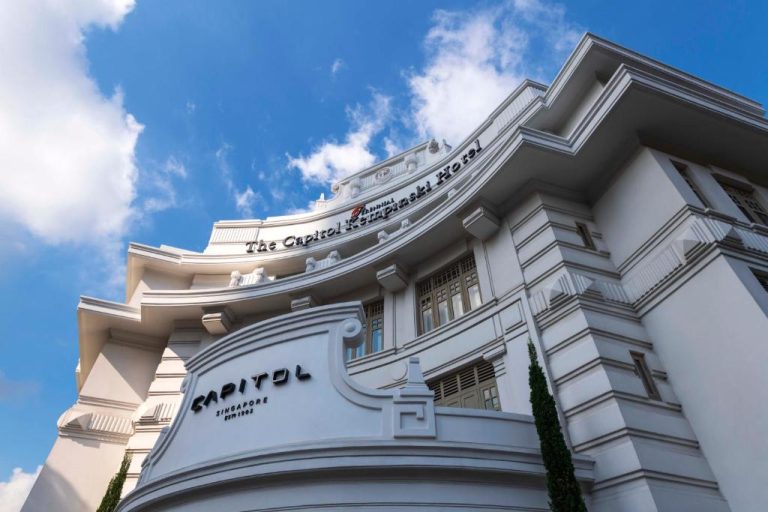 Fachada exterior blanca del The Capitol Kempinski Hotel Singapore con arquitectura colonial y cielo azul
