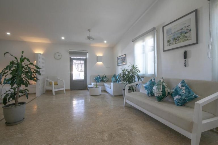 Amplio salón con sofás blancos y cojines tropicales en El Cactus Luxury Apartments del centro histórico
