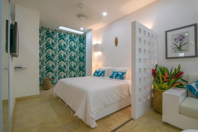 Habitación doble con decoración tropical y pared de hojas en El Cactus Luxury Apartments del Centro Histórico