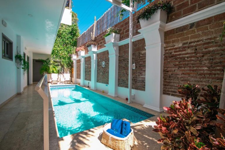 Piscina privada en patio interior con paredes de ladrillo en El Cactus Luxury Apartments del Centro Histórico