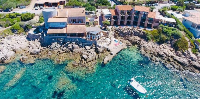 Vista aérea del Hôtel du Golfe con aguas cristalinas turquesas y costa rocosa en Córcega