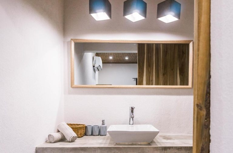 Baño moderno con lavabo sobre encimera y espejo de madera en Fisheye The Rooms
