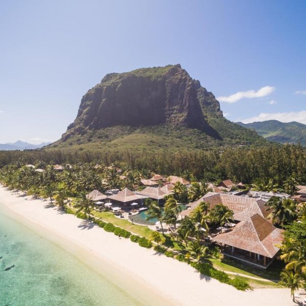 Vista aérea del LUX* Le Morne Resort con villas, palmeras y playa de arena blanca frente al monte Le Morne